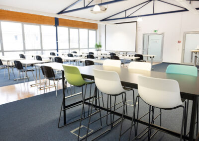 Ein Seminarraum mit Tischen, Stühlen und Hochstühlen